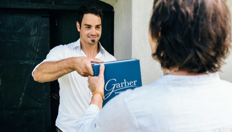 Garber Patrick mit Weinkarton und Kundin