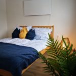 großes gemütliches Bett mit blauen Polstern und einladendes Ambiente