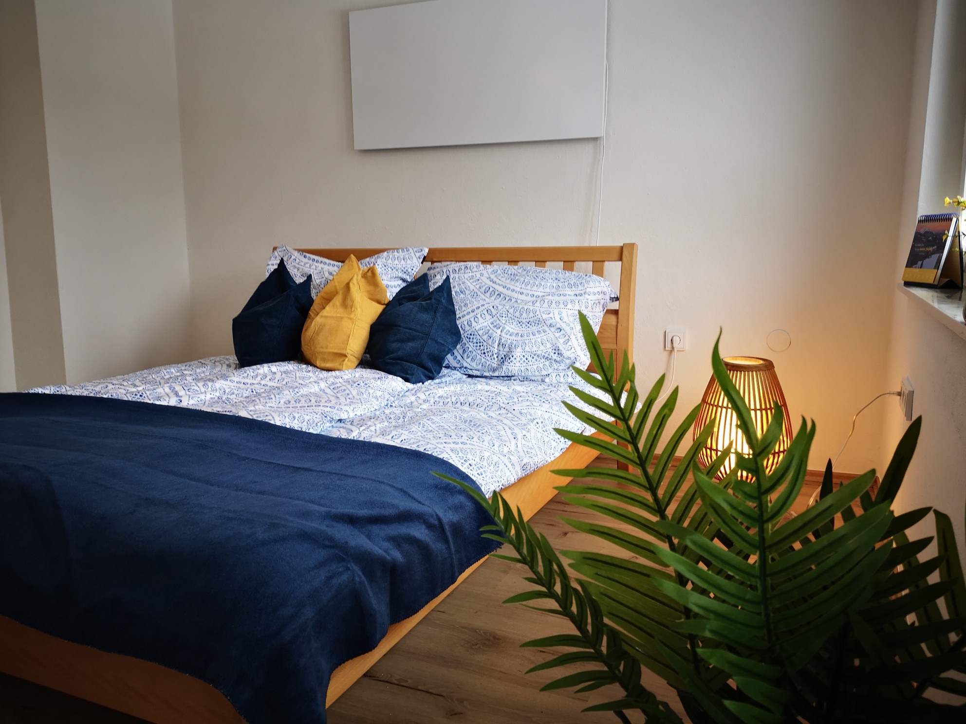 großes gemütliches Bett mit blauen Polstern und einladendes Ambiente
